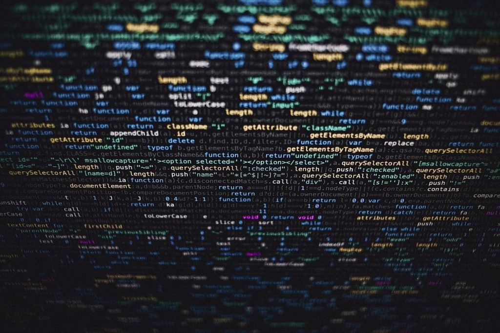 Software developer programming code on black